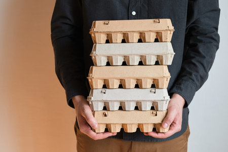 Cardboard boxes with chicken eggs. A man holds boxes with uncooked eggs. Natural organic farm...