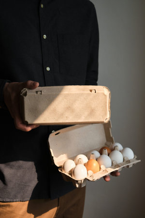 Cardboard boxes with chicken eggs. A man holds boxes with uncooked eggs. Natural organic farm...