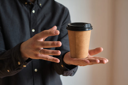 Man holds in hand paper cup with coffee or tea. Businessman drinks coffee. Enjoy moment, take break....