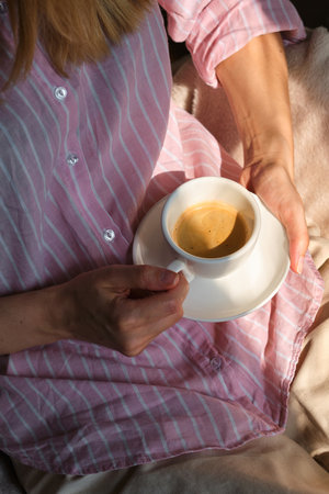 Beautiful woman with a cup of coffee. Businesswoman drink morning coffee after breakfast. Delicious hot espresso in white cup. Enjoy moment, take break. Freelancer lifestyleの写真素材