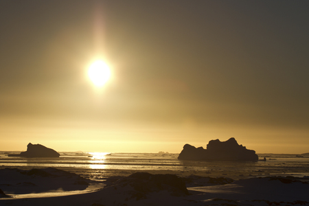 Antarctic icebergs and frozen ocean at sunsetの写真素材