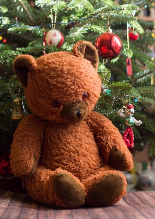 Vintage cheerful stuffed teddy bear toy under the christmas treeの写真素材