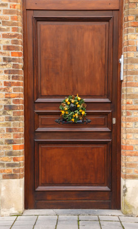 Bruges, Belgium - December 26, 2014: Christmas wreath on a wooden old door. Traditional decoration for Christmas.のeditorial素材
