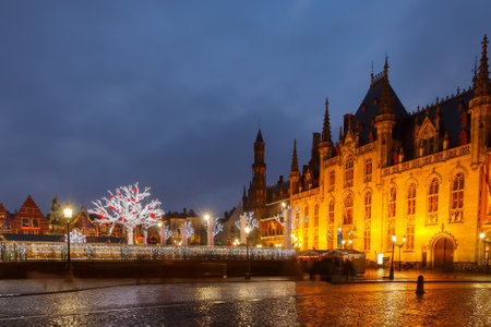Bruges, Belgium - December 23, 2014: Central Bruges Market Square at sunset decorated at Christmas.のeditorial素材