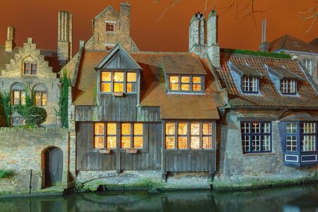 Bruges. Old, stone, medieval house on the canal at night.の写真素材