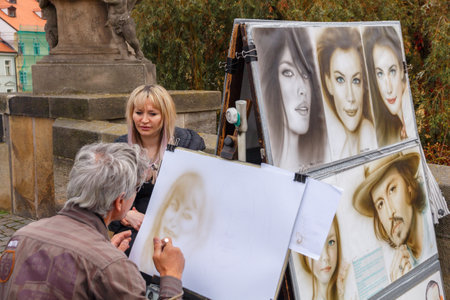 Prague, Czech Republic - October 6, 2014: The artist draws portraits on the Charles Bridge in Prague.のeditorial素材