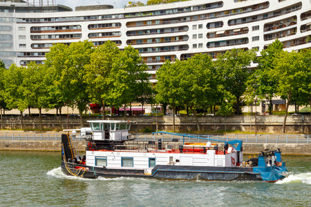 Paris. Pusher ship floating on the River Seine along the city blocks.の写真素材