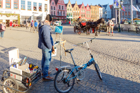 Bruges Belgium December 28 2014: Horsedrawn carriage at the market square in Bruges. Famous colorful facades of houses in the medieval market square.のeditorial素材