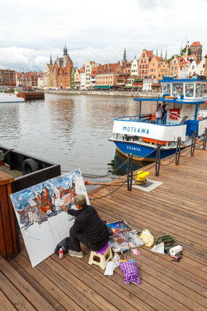 Gdansk, Poland - July 28, 2015:  The artist paints a picture of the central city waterfront in Gdansk. Vintage colorful facades of medieval houses attract a lot artists and tourists.のeditorial素材