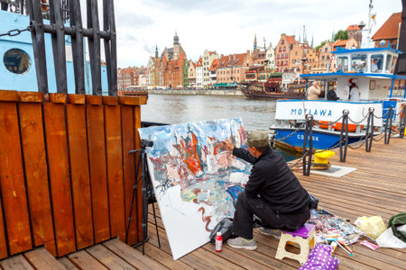 Gdansk, Poland - July 28, 2015:  The artist paints a picture of the central city waterfront in Gdansk. Vintage colorful facades of medieval houses attract a lot artists and tourists.のeditorial素材