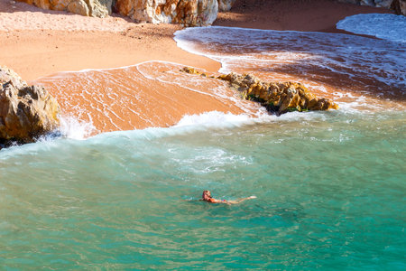 Tossa de Mar, Spain - September 12, 2015:  Women swimming in the bay of Cala Pola. Picturesque places on the Costa Brava in Spain attracts many tourists from all over Europe.のeditorial素材