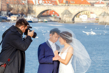 Prague, Czech Republic - December 27, 2015: Prague is the most visited city in Europe and a popular place to get married. Photography of  a young couple in a wedding dress on the bank of the Vltava.のeditorial素材