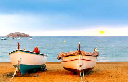 Fishing boats on the beach of Tossa de Mar in the early morning.の写真素材