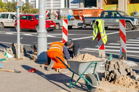 Riga, Latvia - 15 October, 2015: Masons workers make the pavement of stone blocks in the center of Riga.のeditorial素材