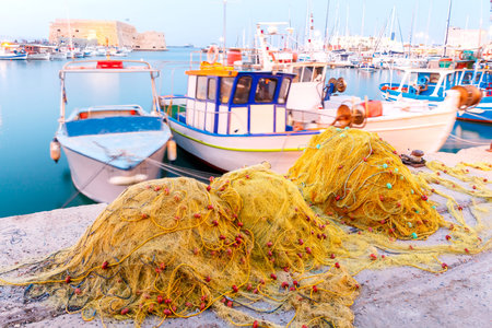 Fishing multi-colored boats in the old harbor of Heraklion in early sunny morning. Crete. Greece.の写真素材