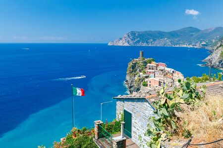 The Italian national flag on a background of blue sea in the village Vernazza.の写真素材