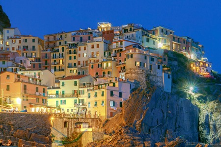 A view of the colorful traditional houses on the rock on sunset. The coast of Liguria. Manarola. Cinque Terre.の写真素材