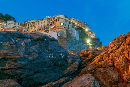 A view of the colorful traditional houses on the rock on sunset. The coast of Liguria. Manarola....