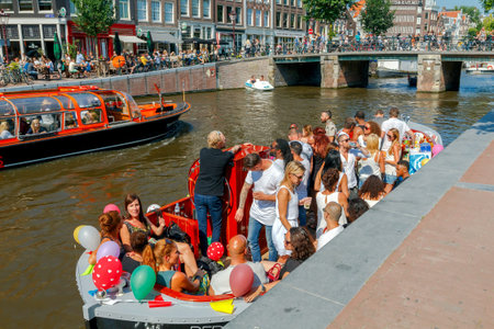 Amsterdam, The Netherlands - August 27, 2016: Excursions by boat on the canals of Amsterdam. Favorite place for walking and leisure travelers.のeditorial素材