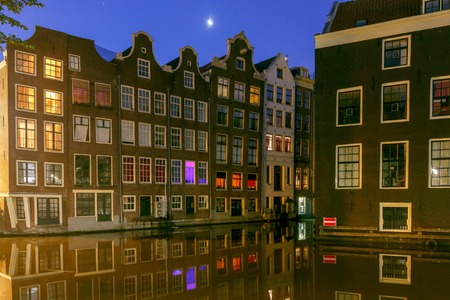 Facades of traditional Dutch houses on the canal in the night light. Red light district. Amsterdam. Netherlands.の写真素材
