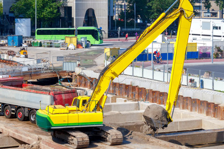 Large excavator in the foundation pit of the construction site.