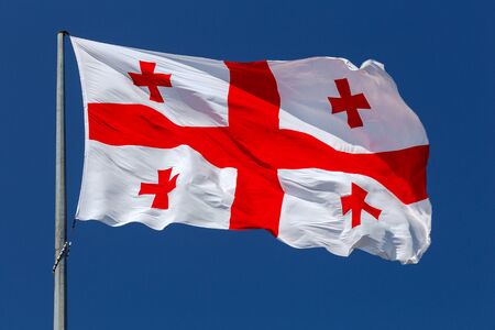 National flag of Georgia against the blue sky.の写真素材
