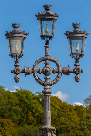 Old street lamp in the park against the sky.の写真素材
