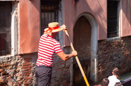 Venice. Gondolier in a traditional gondola on a sunny morning.の写真素材