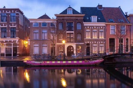 Beautiful old houses on the city embankment of Leiden at sunset.の写真素材