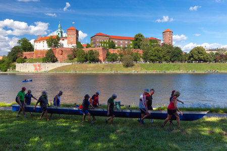 Tourists carry a kayak along the embankment of Krakow.のeditorial素材