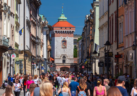 Tourists on the central street of Krakow on a sunny day.のeditorial素材