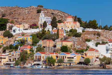 Colorful traditional multi-colored houses on the shore of the bay on Symi island.