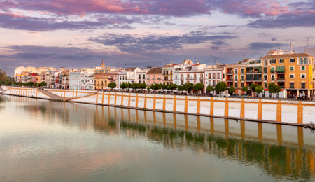 Colorful houses along the city promenade in Seville at sunset.