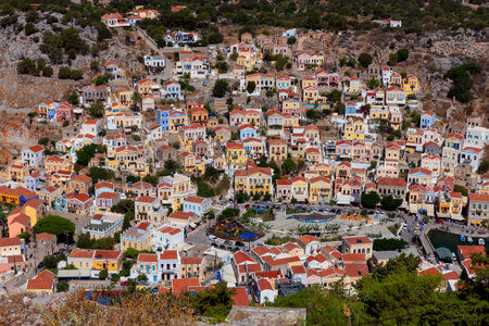 Aerial view of colorful traditional multi-colored houses on a mountainside on Symi island.