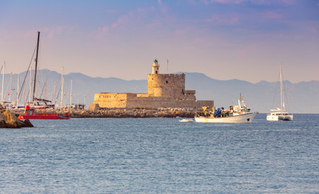 Old stone lighthouse in Fort St. Nicholas in Rhodes at sunset.の写真素材