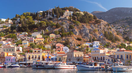 Multi-colored facades of houses in the village of Symi at sunset.の写真素材
