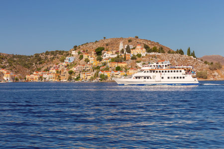 Multi-colored facades of houses in the Greek village Symi on a sunny day