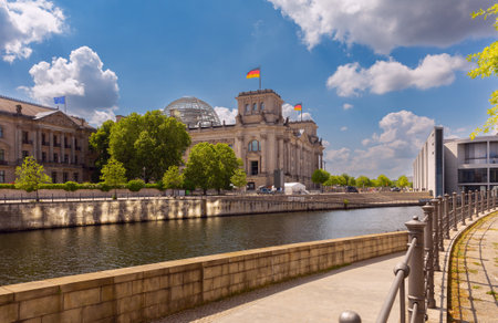 A picturesque view of the embankment and the waving German national flags on the Reichstag building against the blue sky. Berlin. Germany.の写真素材