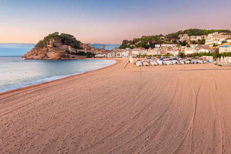 Morning view of the beach and medieval fortress of Tossa de Mar at sunrise, Catalonia, Spainの写真素材