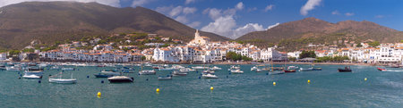 Panoramic view of Cadaques with mountains in the background on a sunny dayの写真素材