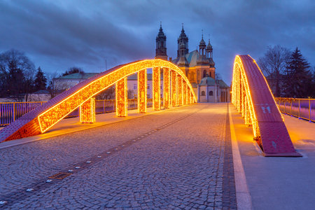 Illuminated bridge to the cathedral on Tumski Island at sunrise, Poznan, Polandの写真素材