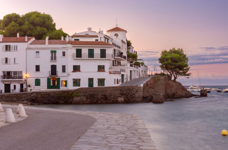 Old houses along the central city street of Cadaques on the shore.
