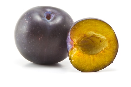 ripe plums, pitted and half on white backgroundの写真素材