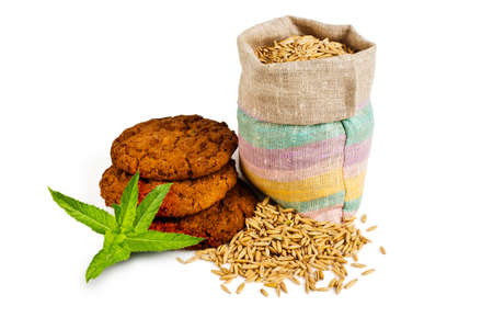 A bag of grains of oats and oatmeal cookies on a white backgroundの写真素材