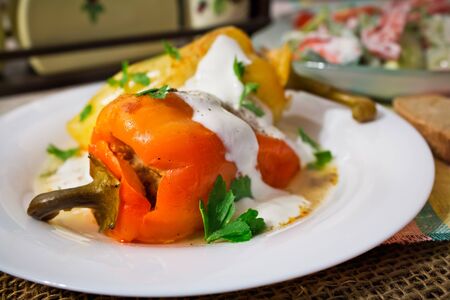 Baked stuffed bell peppers with parsley on a plateの写真素材