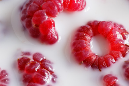 Fresh ripe raspberries bathed in milk for breakfastの写真素材