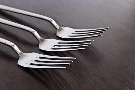 Canteens stainless steel cutlery on dark wooden surfaceの写真素材