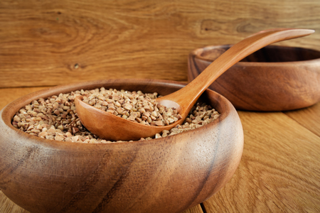 Buckwheat in a wooden bowl and with a wooden spoonの写真素材