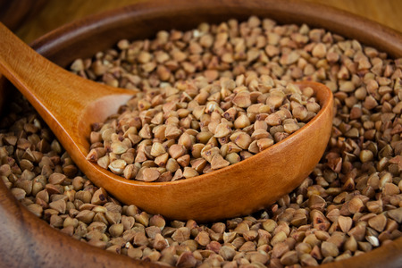Buckwheat in a wooden bowl and with a wooden spoonの写真素材