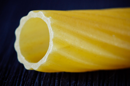 Pasta in the form of a tube close up on a black backgroundの写真素材